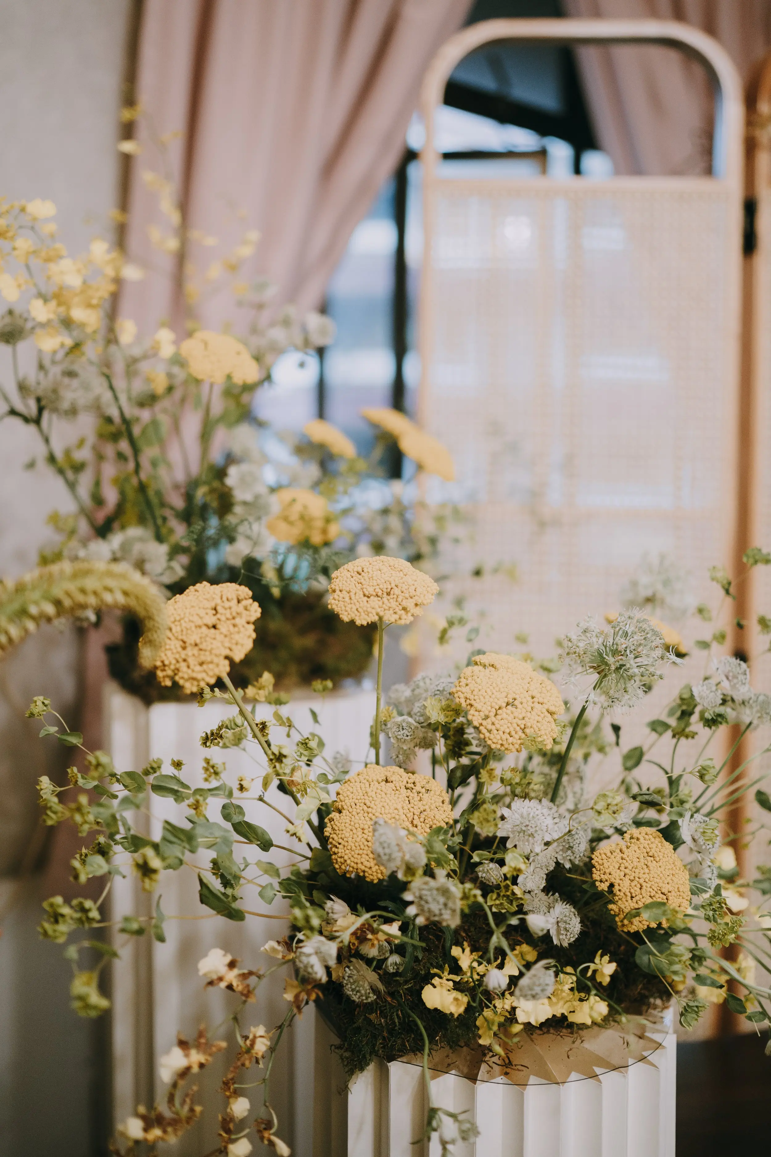 Framing the sides with plinth columns dressed in yellow and pink florals that create an interesting backdrop
