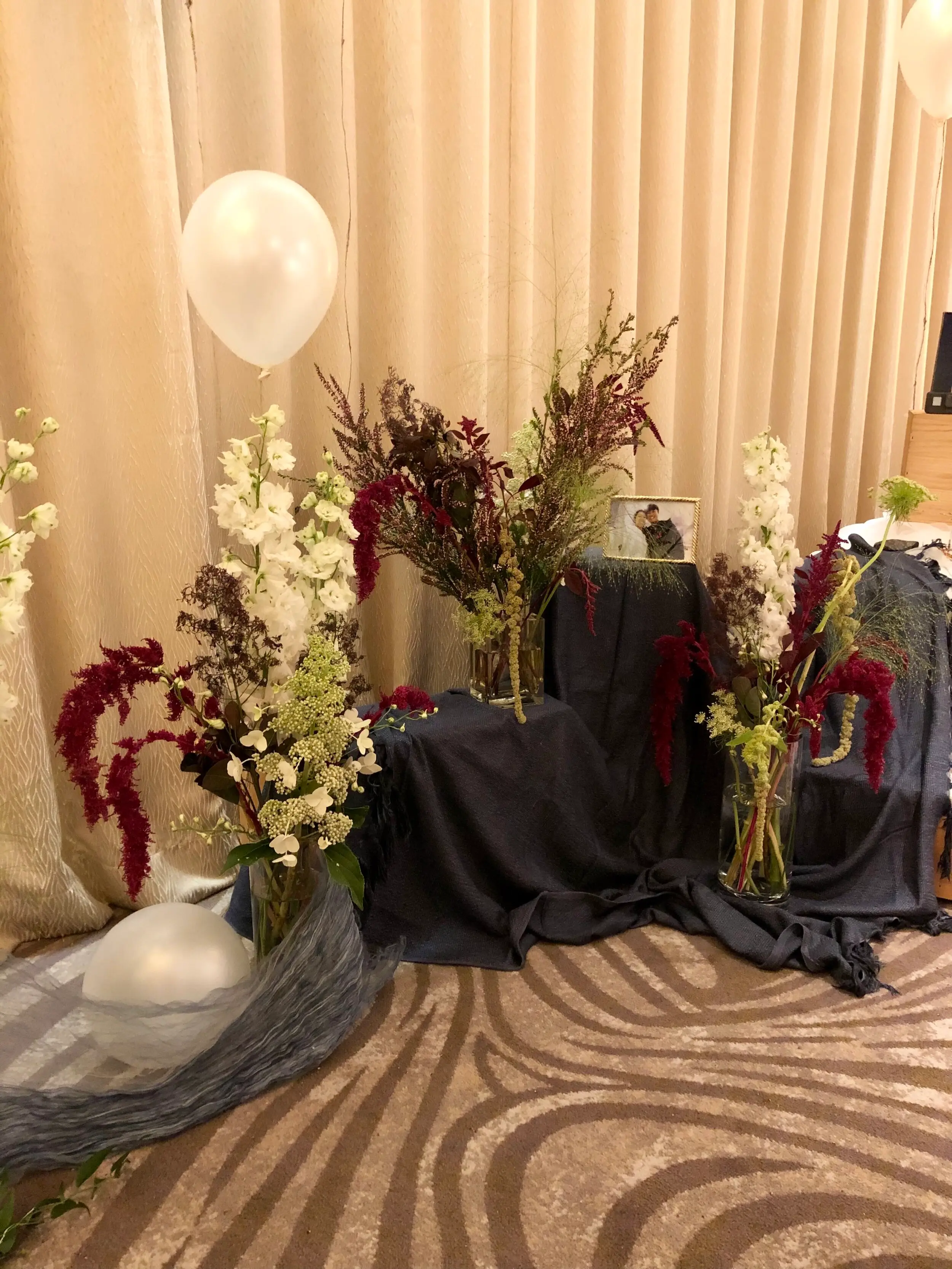 Hanging amaranthus with curved forms that complement the prints on the carpet flooring.