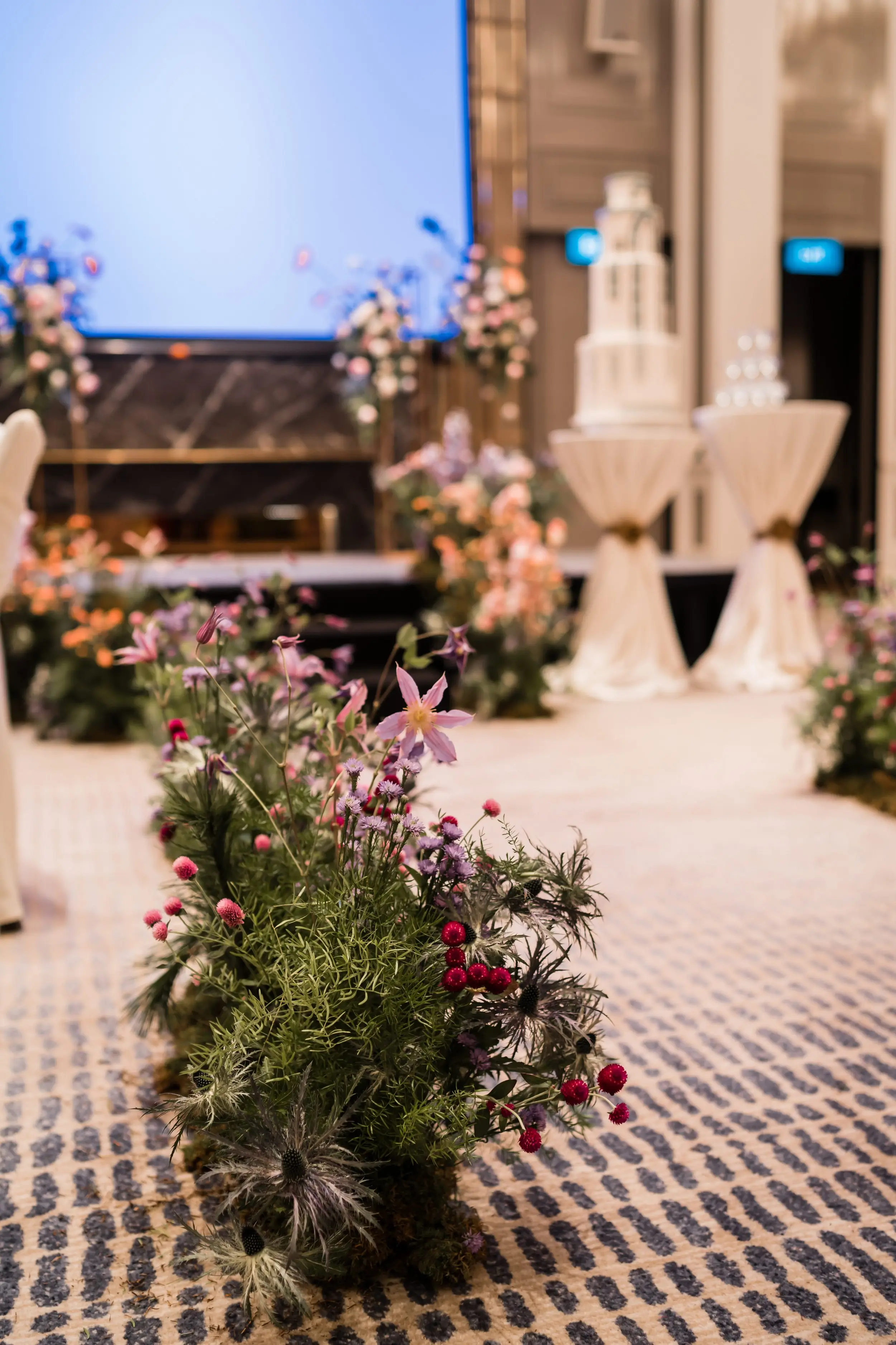 Aisle hedges styled using more wildflowers to counterbalance against the sweeter look of the stage, and to add more visual interest