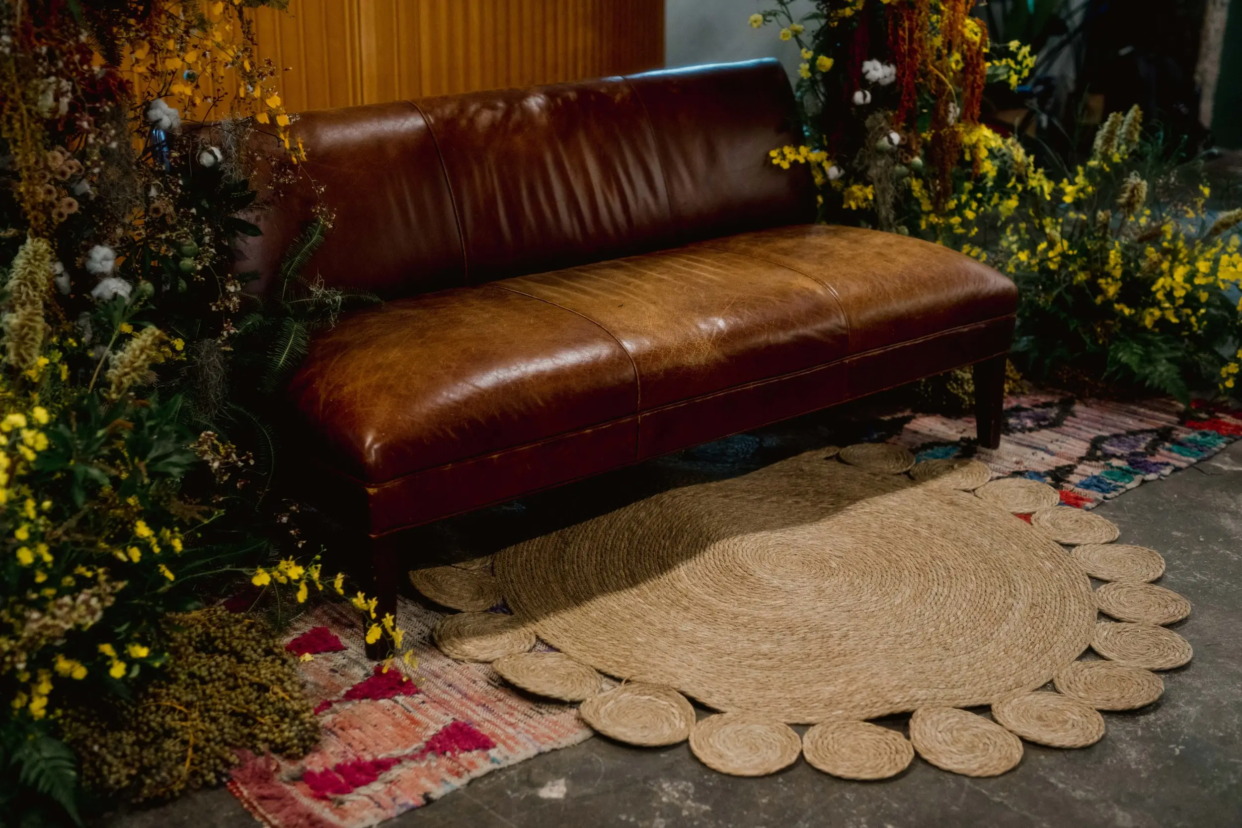 A muted rattan mat to tone down the colors for the foundation of the dais bench and complement the florals.