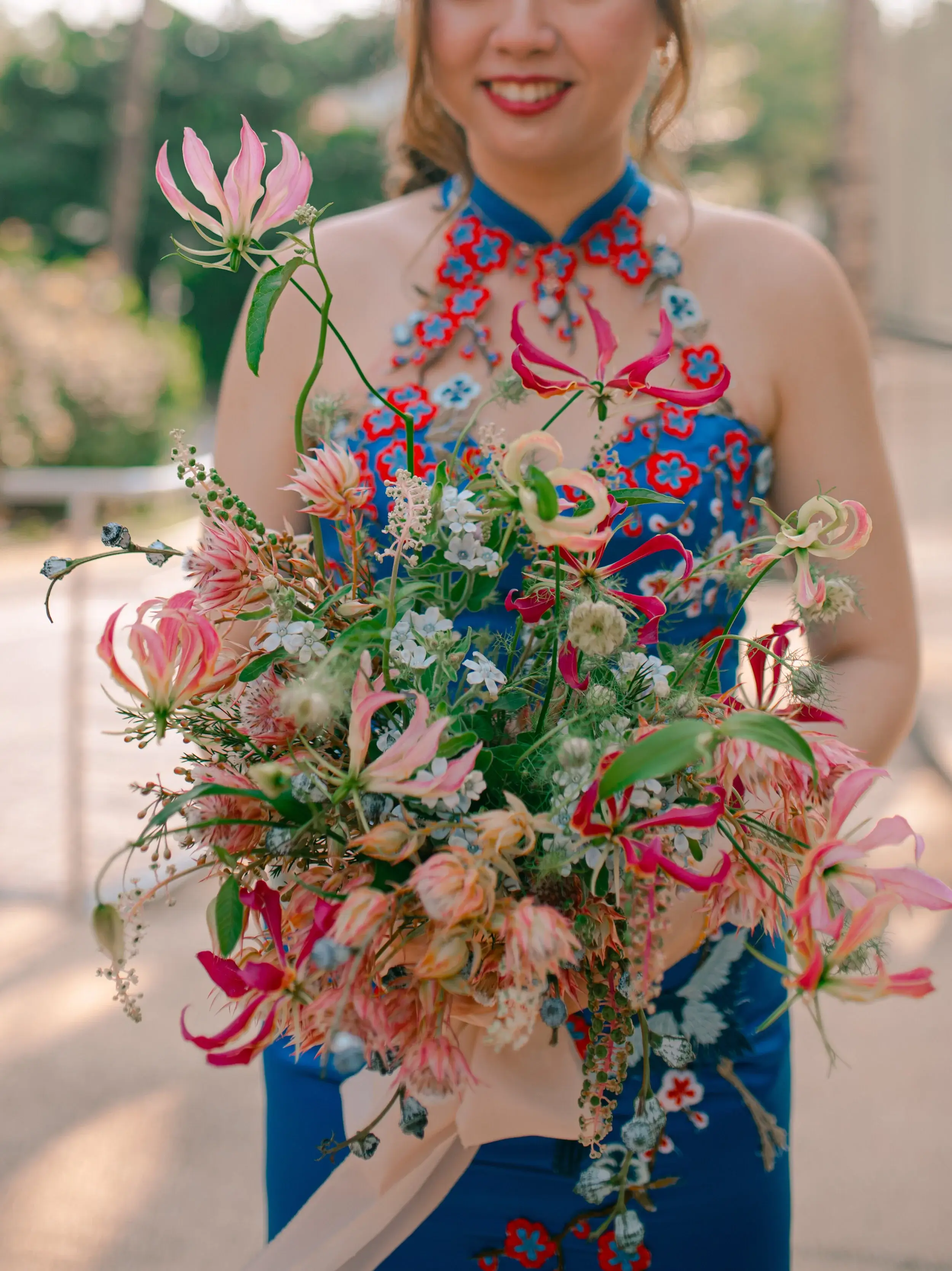 Red gloriosa lilies mimicked cranes in flight, which were a unique embroidery feature of the gown. Gown design: Rico-A-Mona Bridal. Image Credits: Nicole from Patchwork Pictures